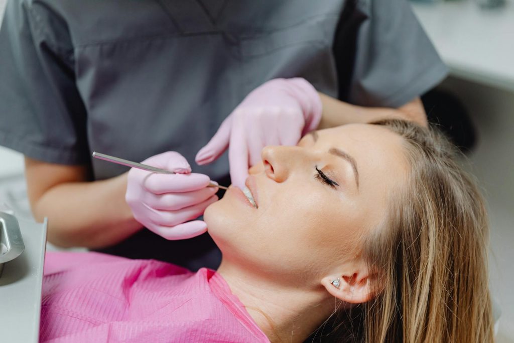 Photo of a Woman with Makeup Getting a Dental Check Up